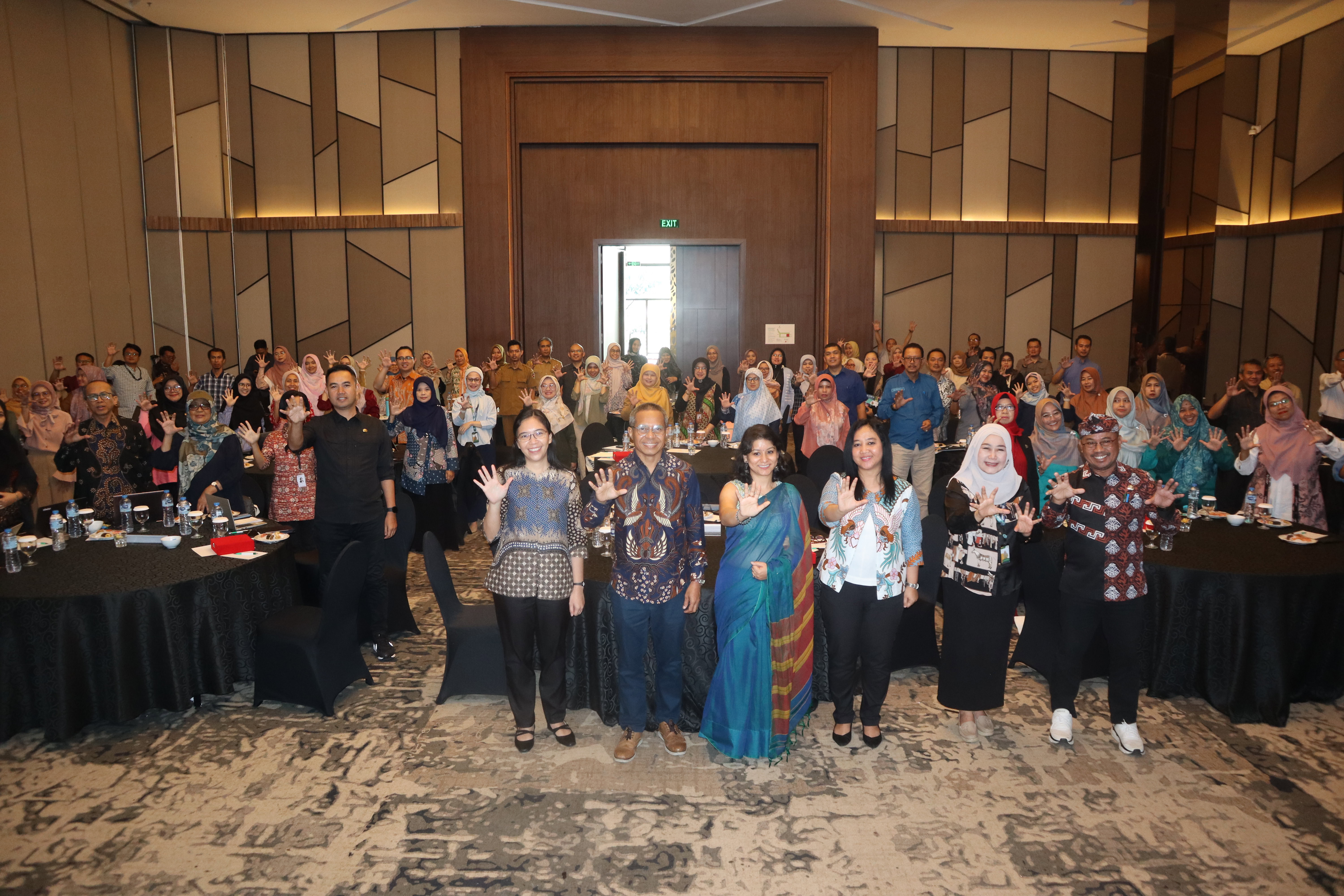 A group of people facing the camera holding up their hands