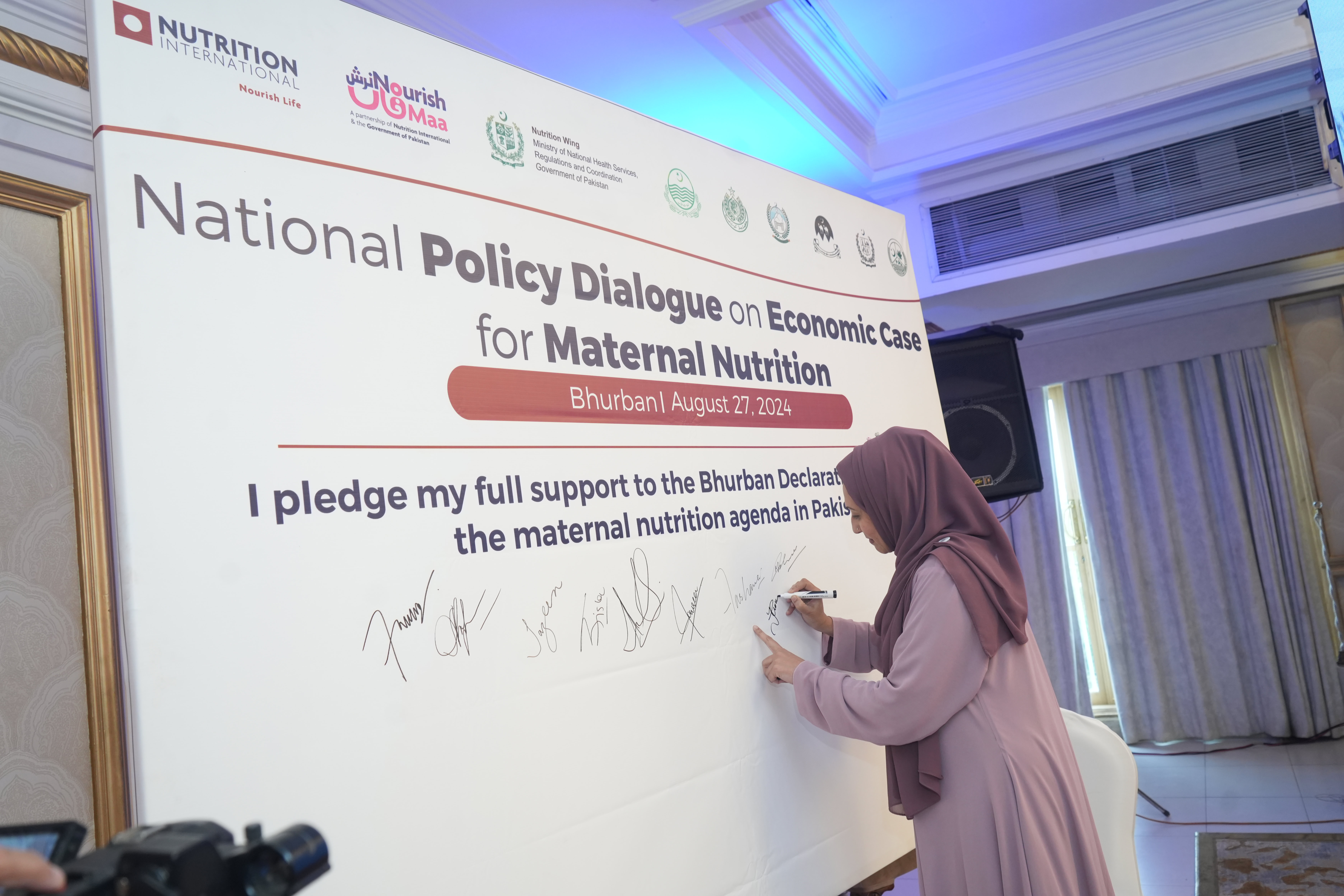 A woman signing a board.