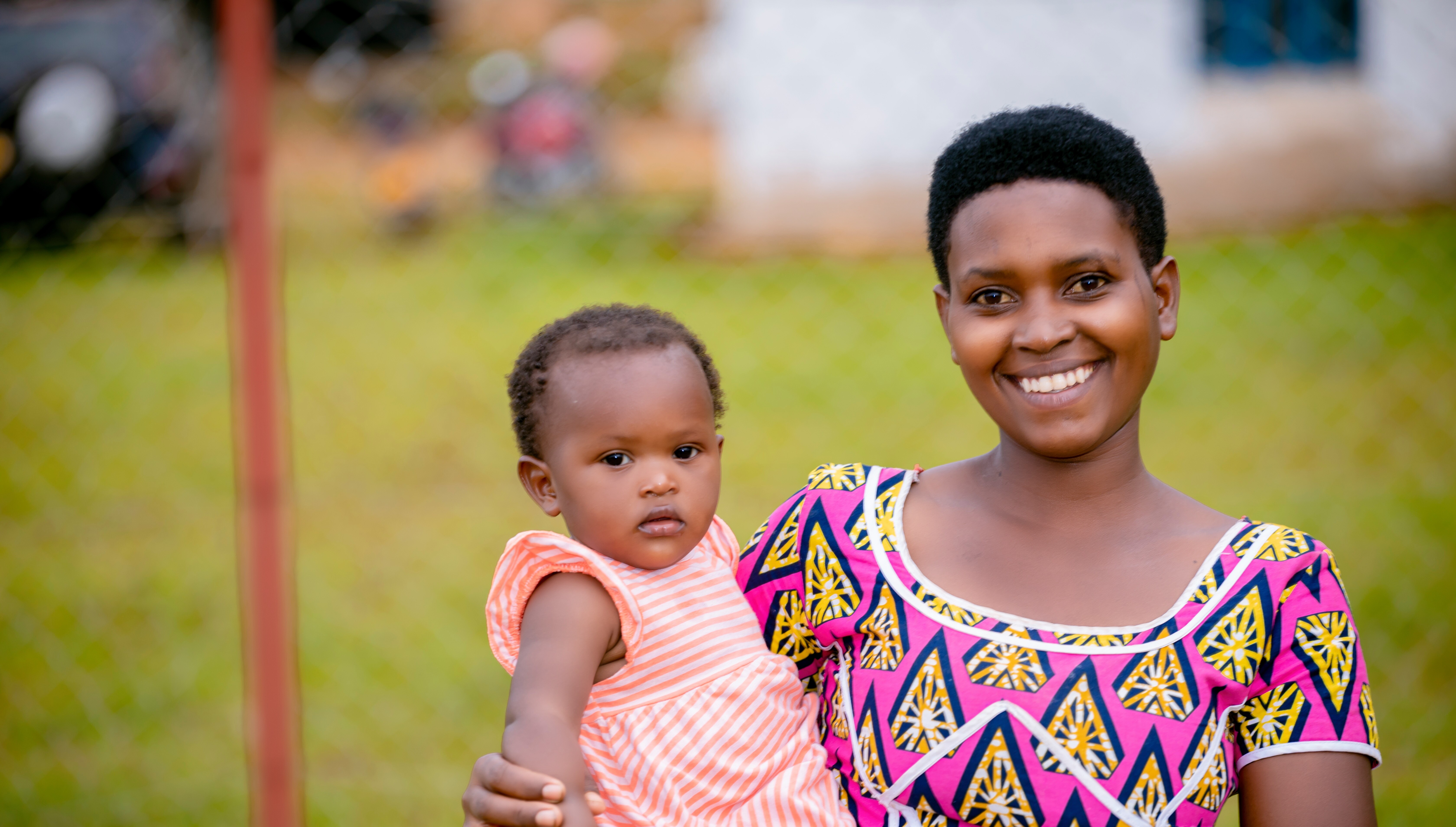 A woman holds a baby smiling to camaera.