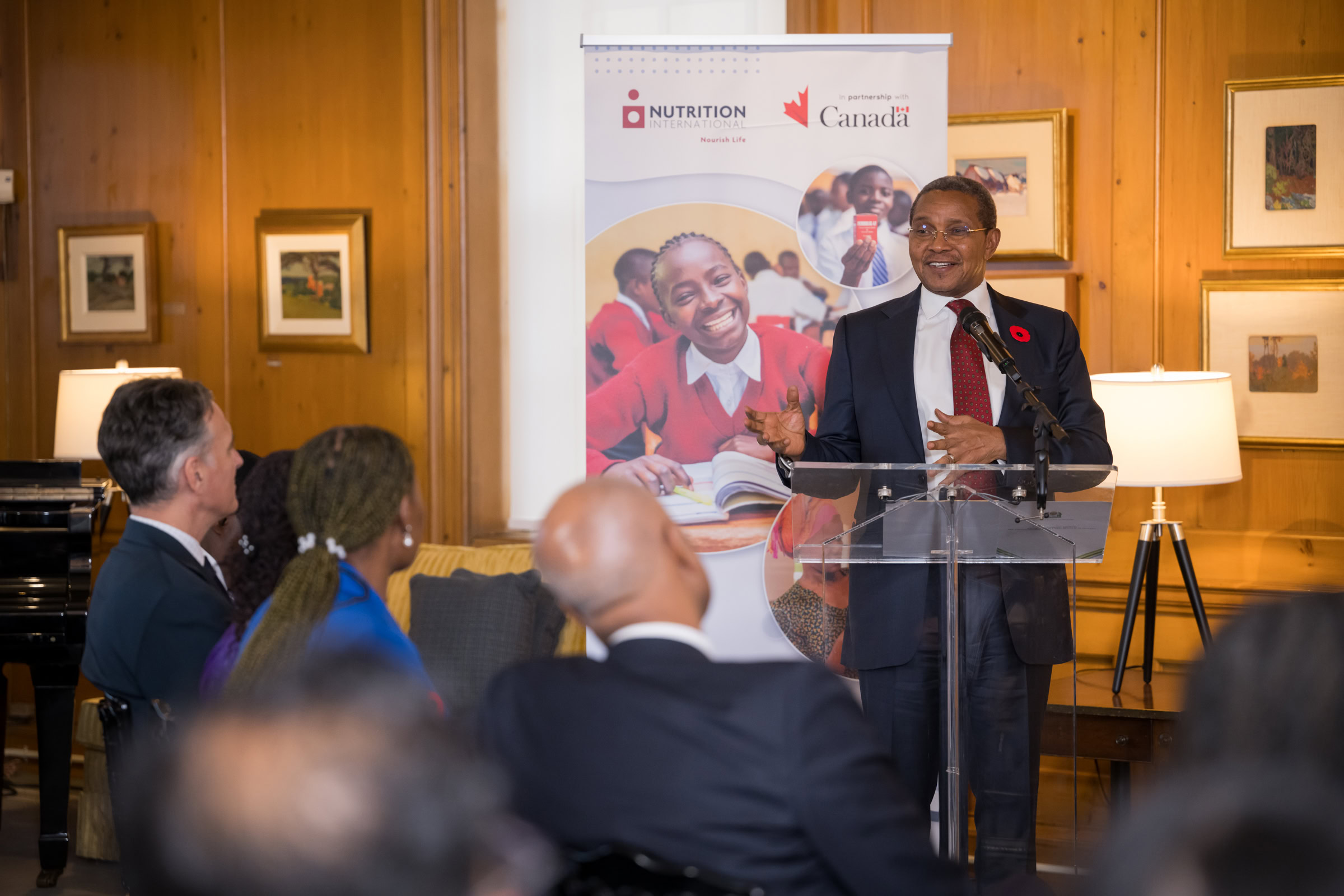 A man standing at a podium delivers a speech to an audience.