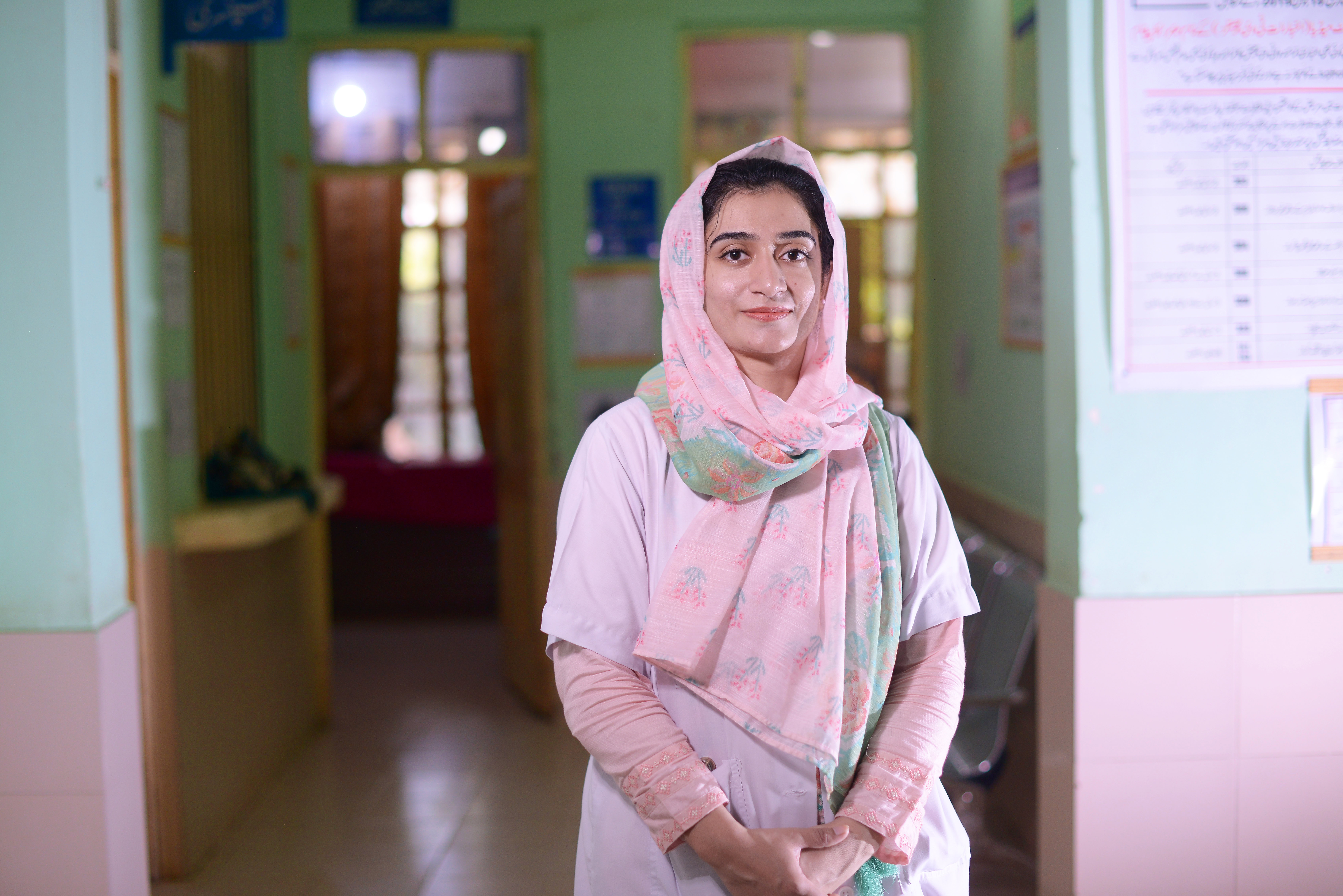 A woman stands in the middle of a room smiling to the camera.