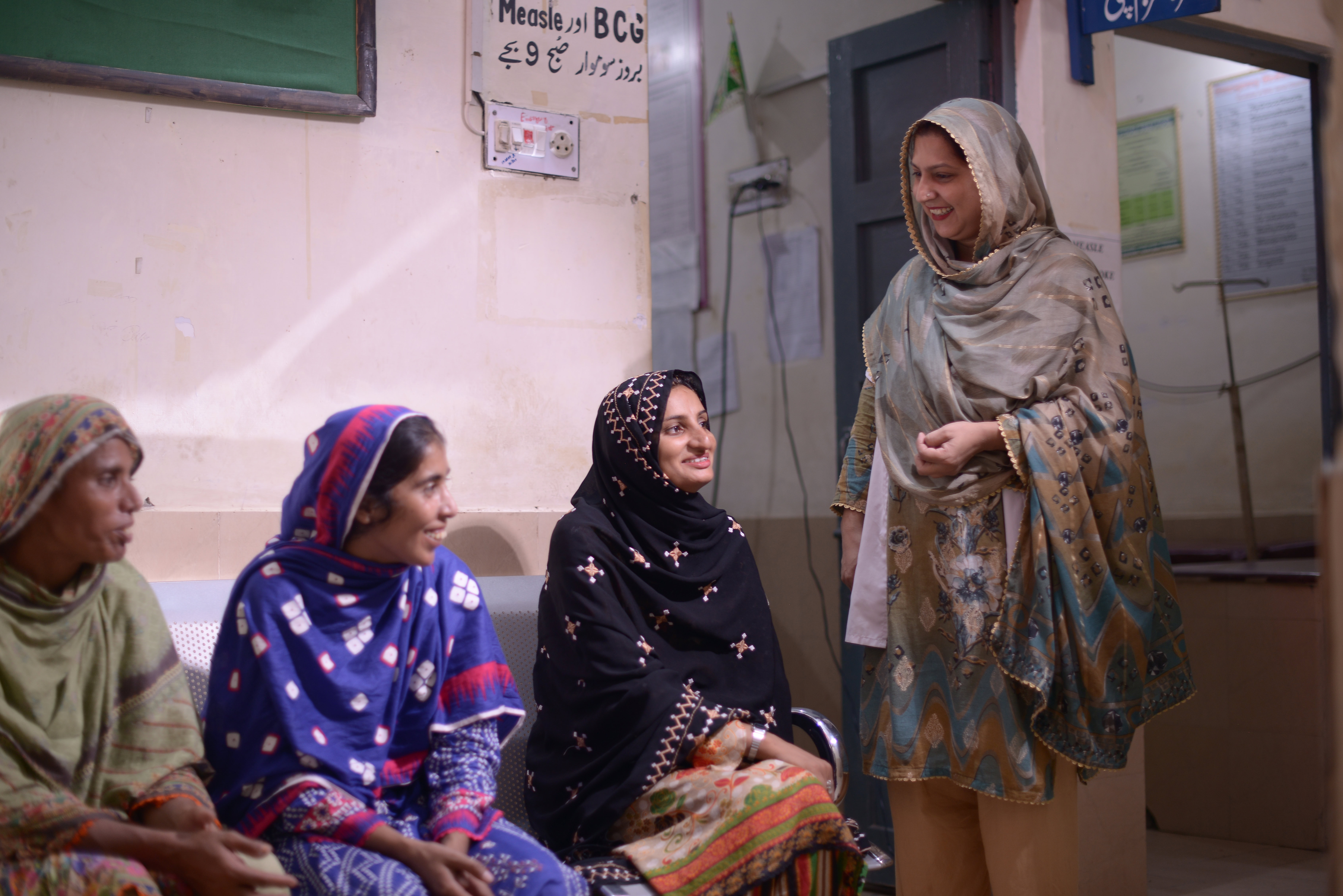 A woman greets clients waiting at basic health unit.