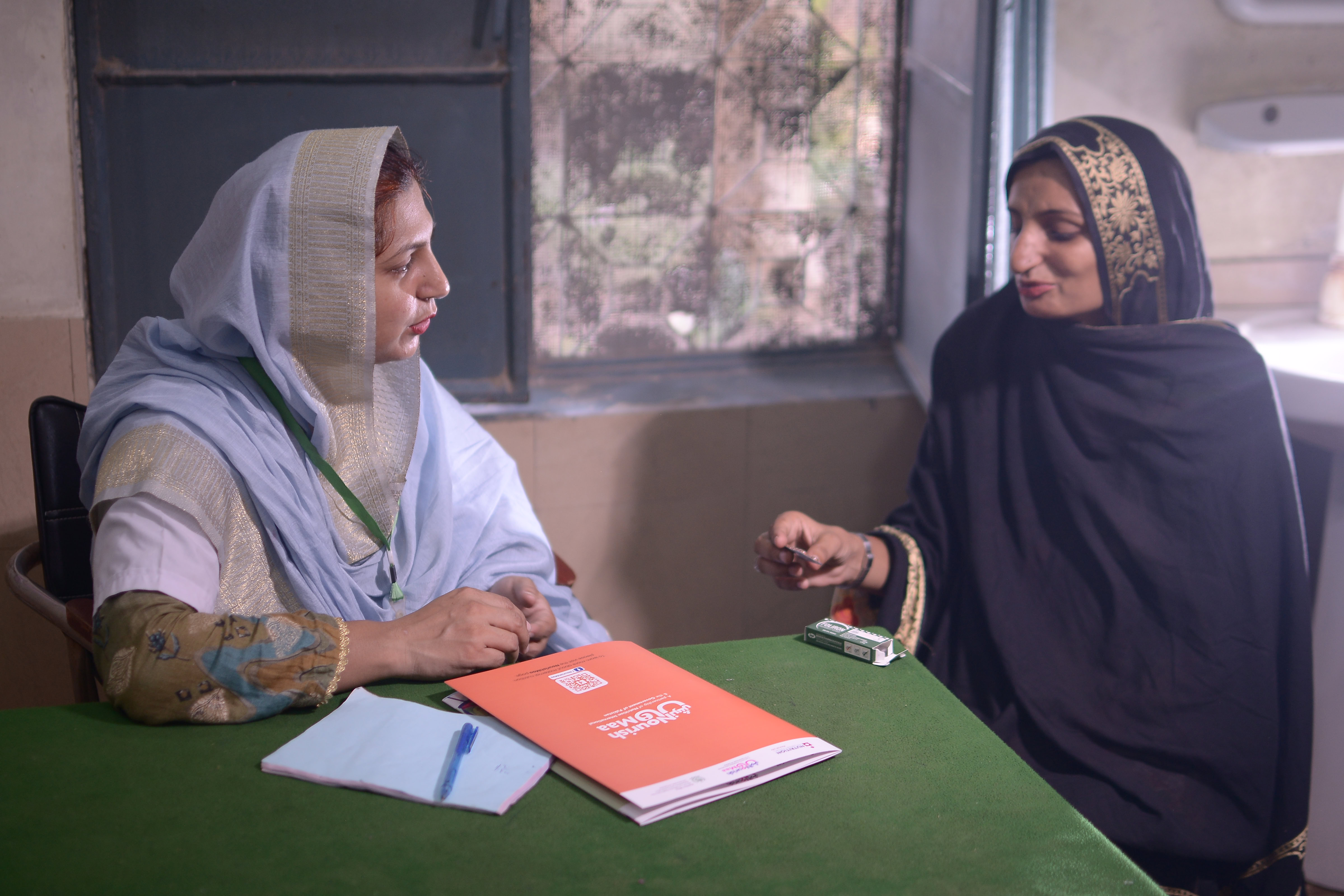 Two people discussing and sitting at a table.