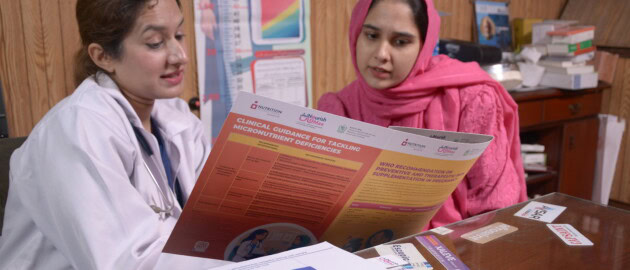 A doctor reviews materials with a pregnant woman