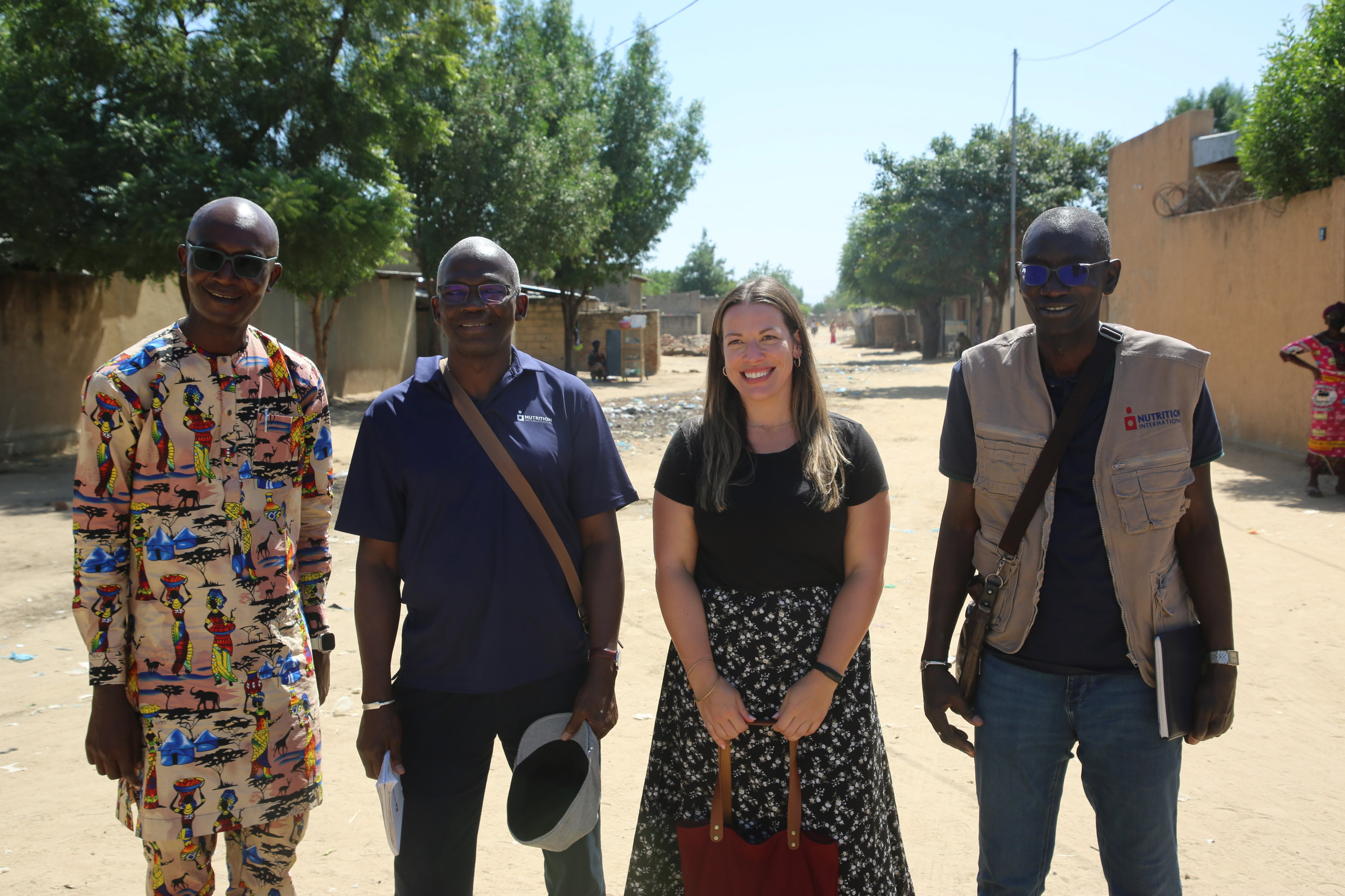 Nutrition International staff outside in the capital of Chad, smiling to the camera. 