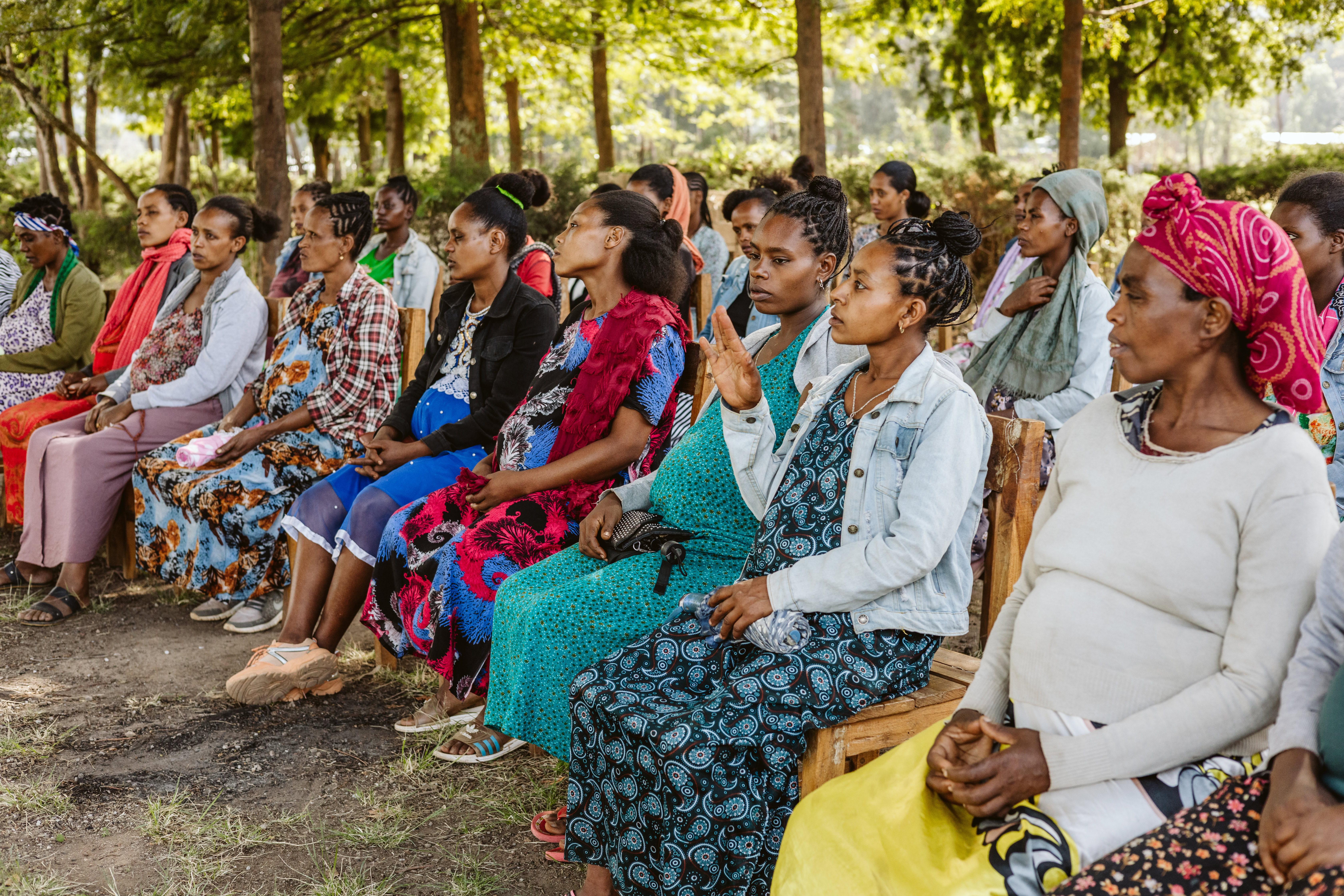 A group of pregnant women are seated outside at a pregnant women's conference in Ethiopia.