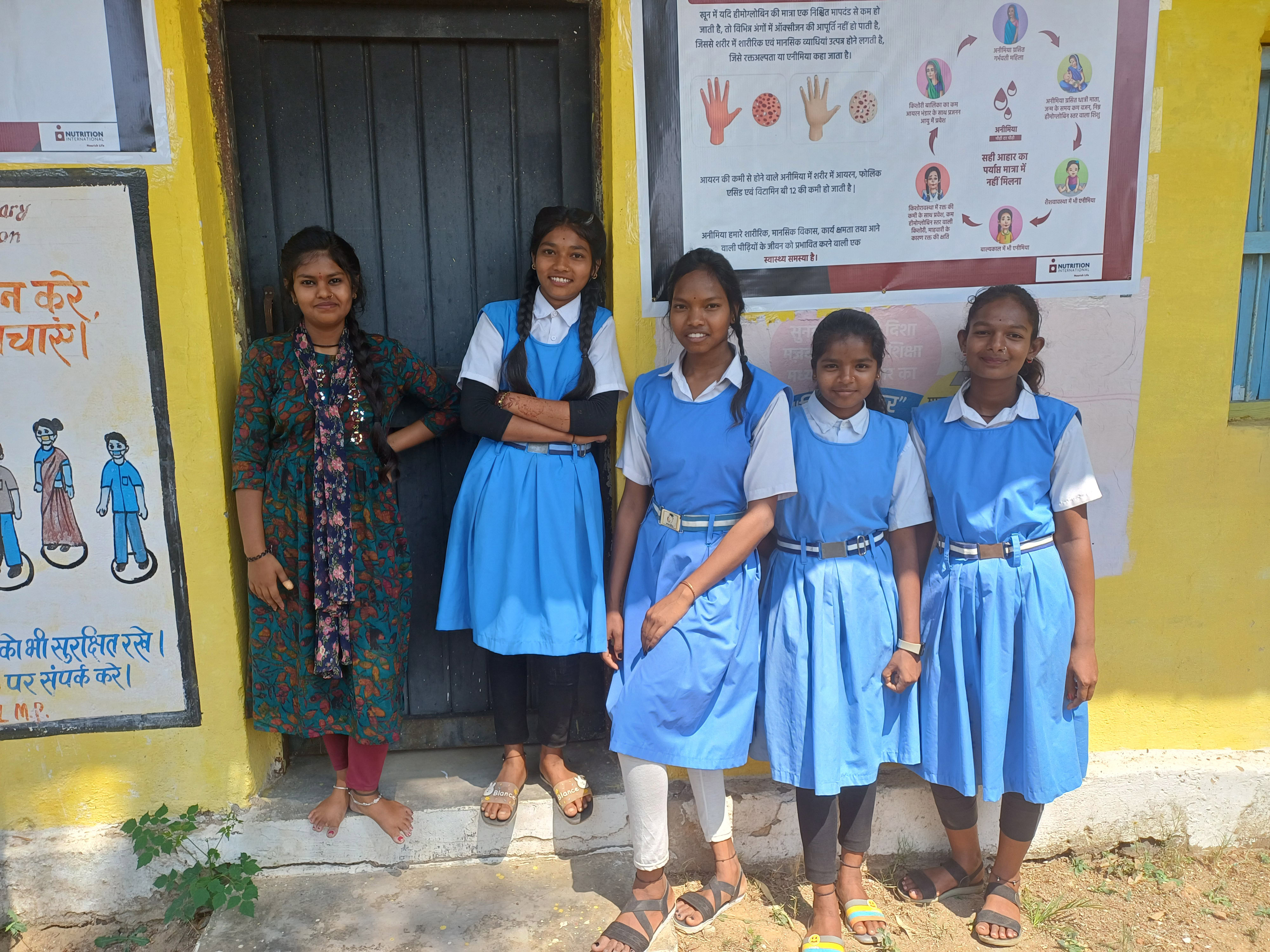 20240425_140606 - Nutrition International A group of students in their school uniforms stand outside smiling to the camera