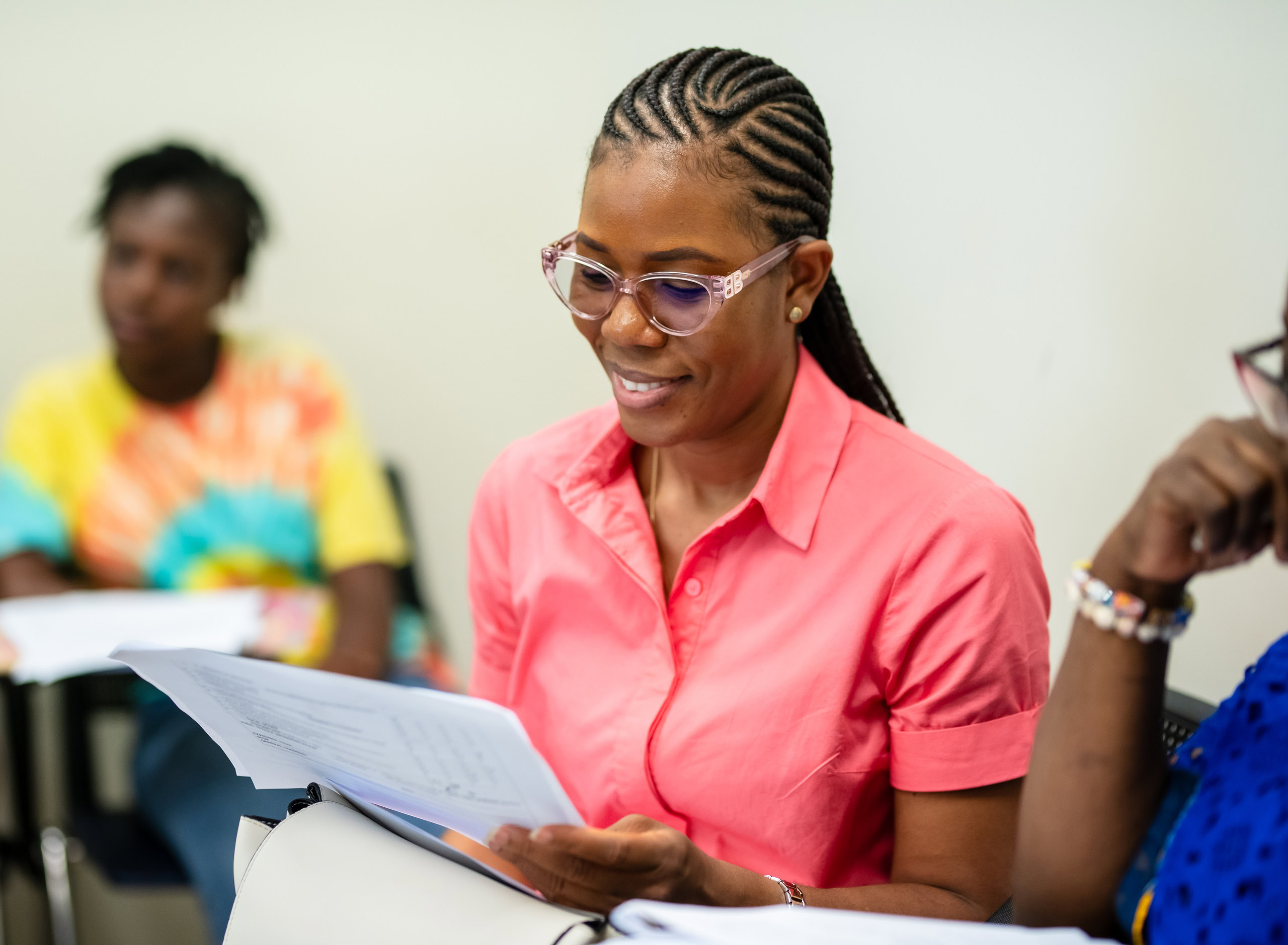 A female student sits holding a piece of paper.