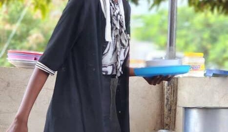 A woman standing outside serving food