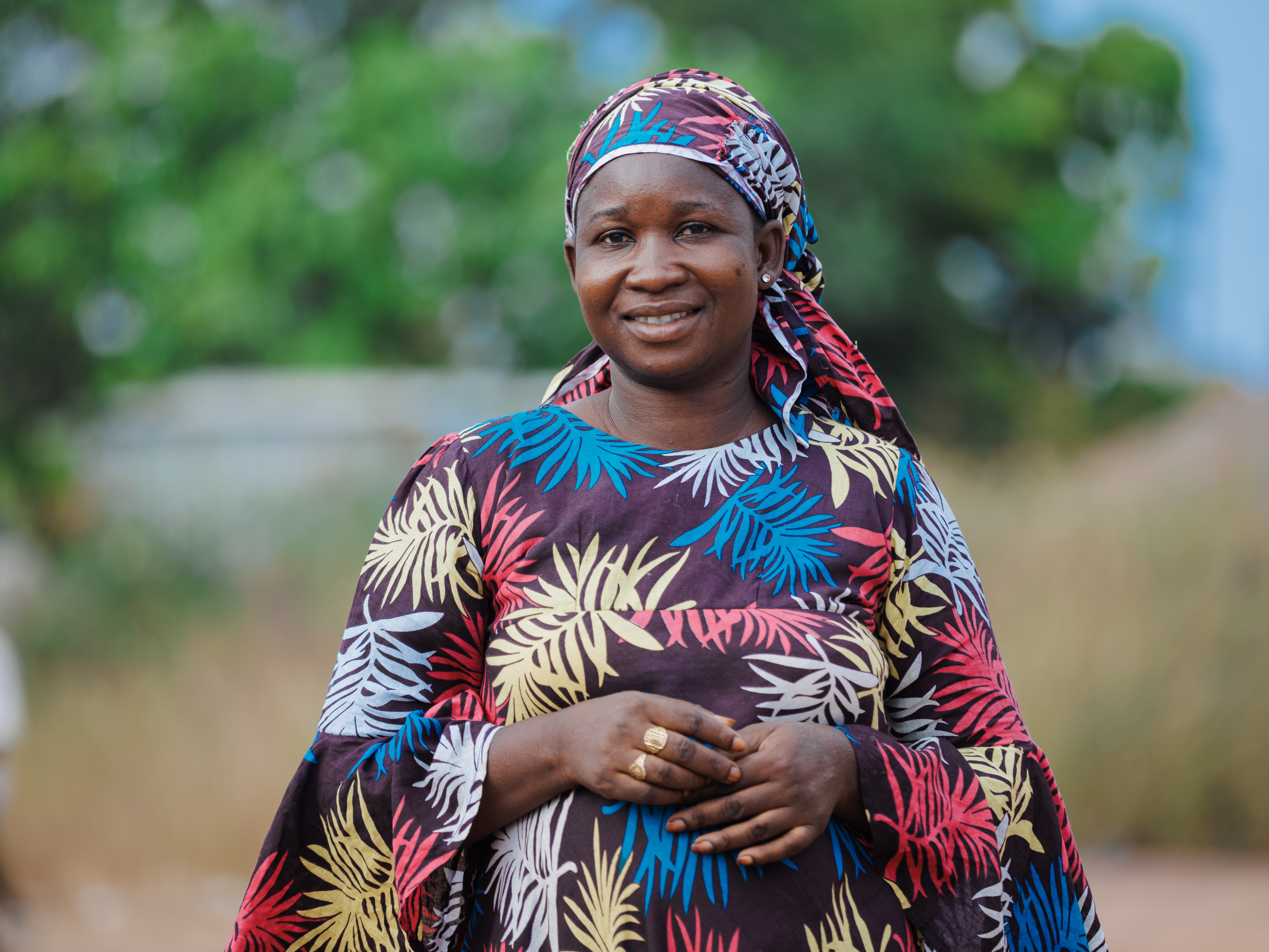 A woman stands smiling to camera