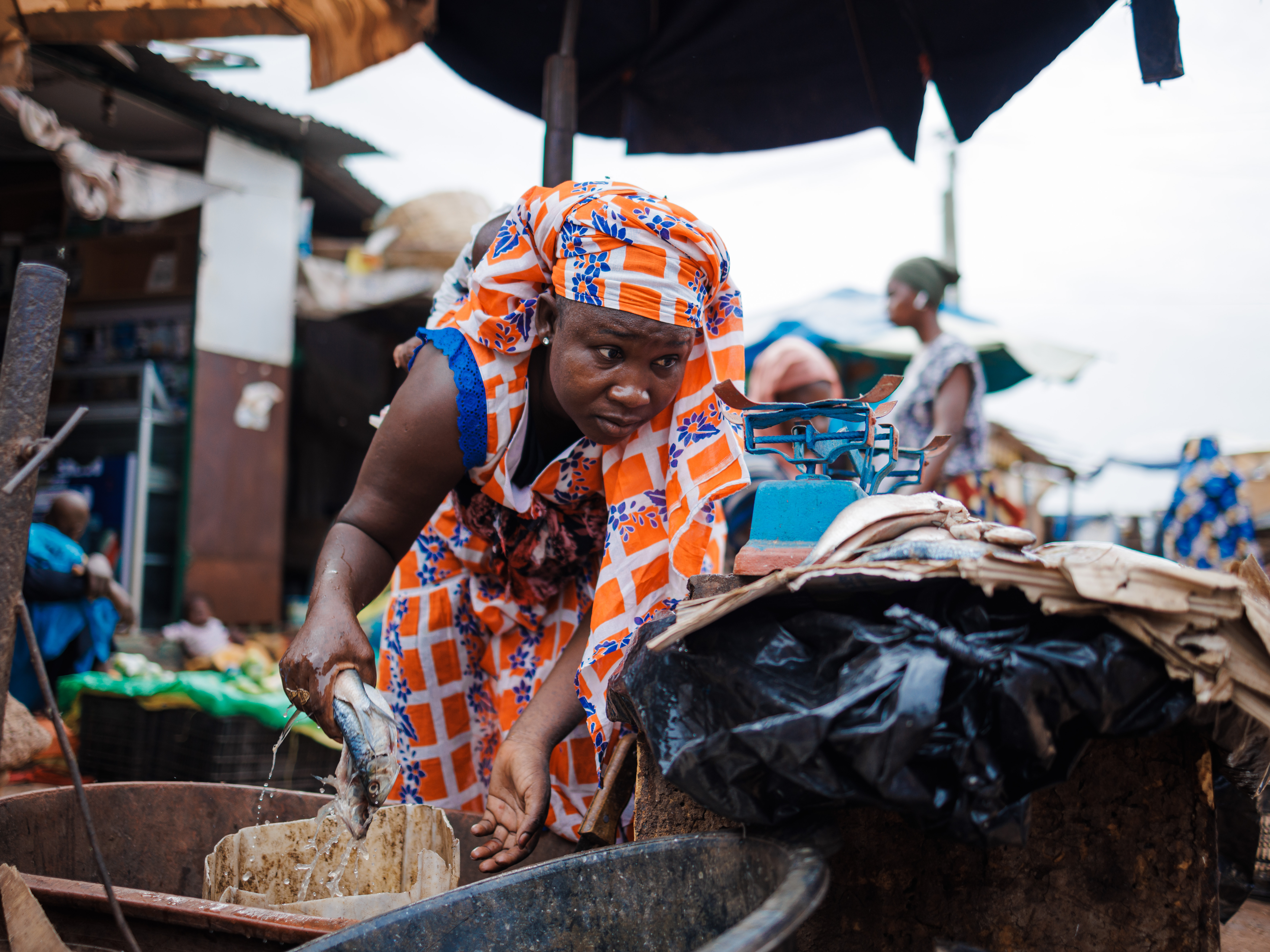 A woman in a bright orange and blue dress adjust fis