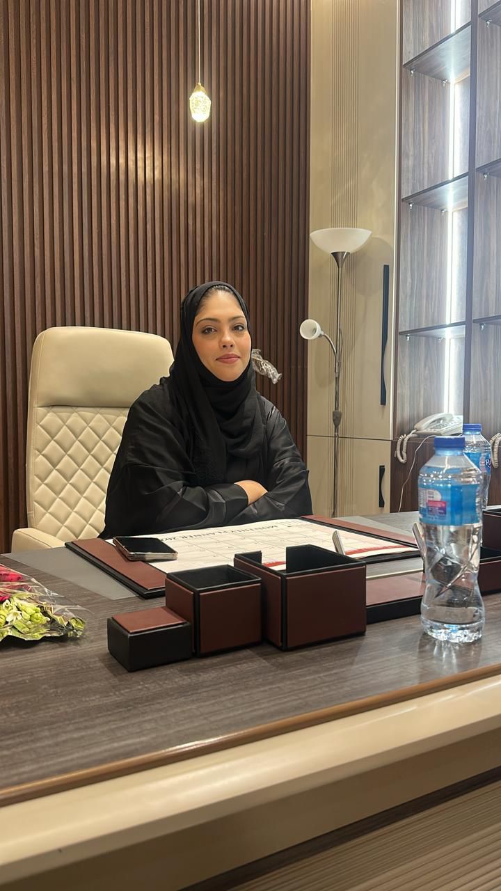 A woman sits at a desk