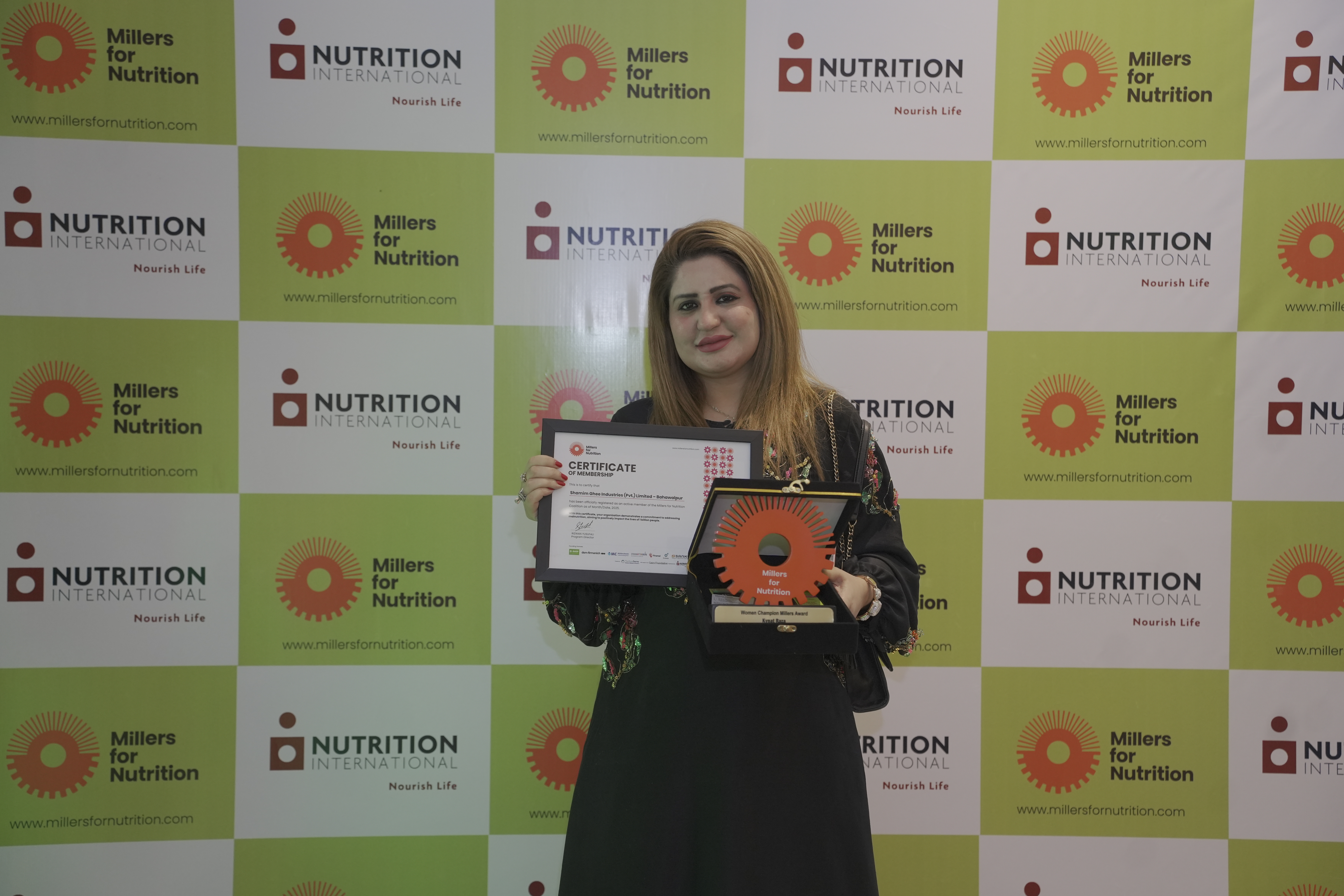 A woman holding an award at the Pakistan Millers Association Launch