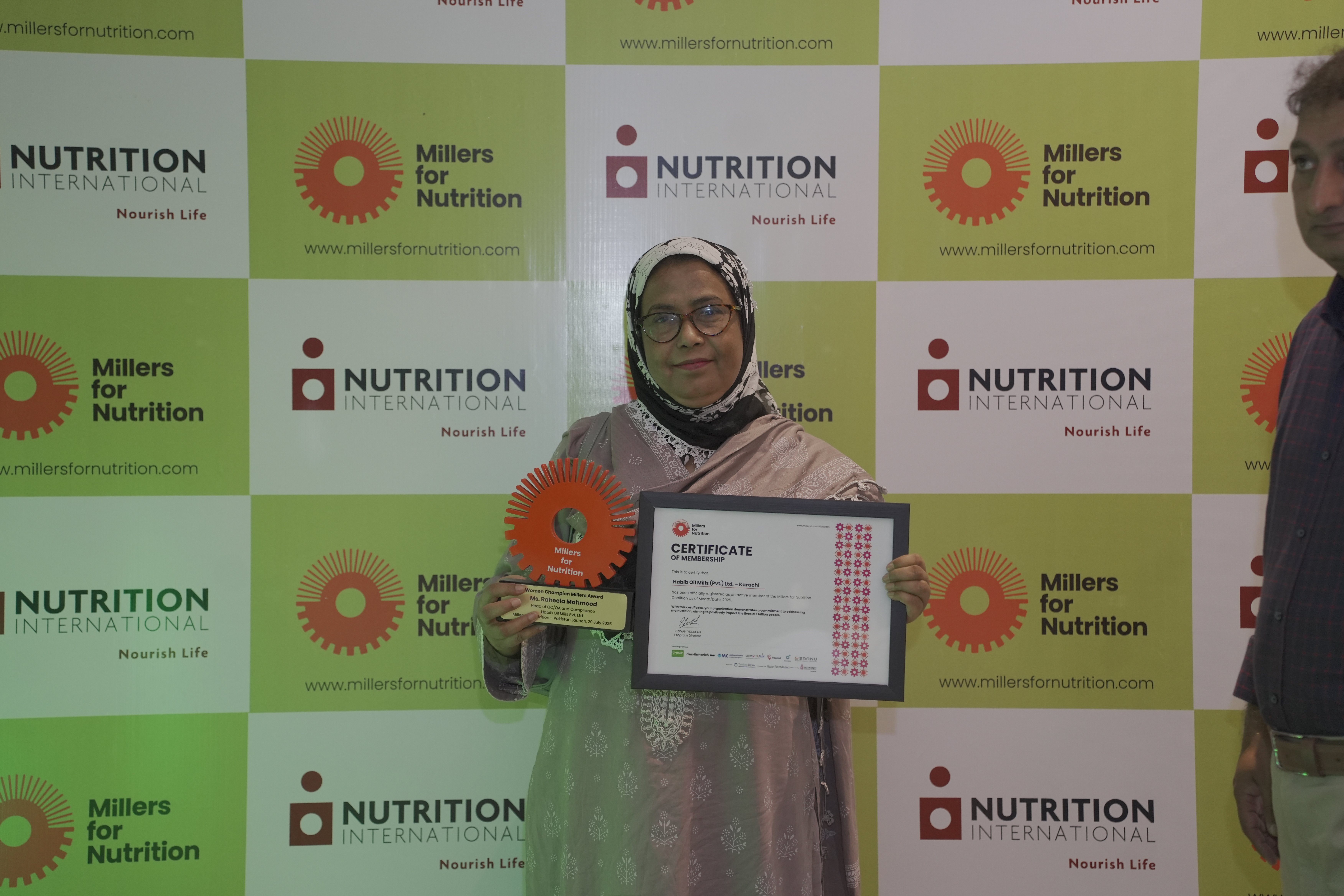 A woman holding an award at Pakistan Millers for Nutrition launch